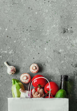 Food delivery. Various food in a paper bag on a concrete background. Product purchase concept, top view with copy space.の写真素材