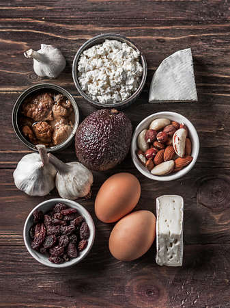 A set of foods containing healthy sources of omega-3, calcium and healthy fats on a wooden background top view. Vegetables, seafood, nuts and cheese.の写真素材