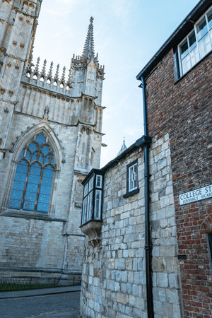 York Minster cathedral towers on a sunny summer day with a clear blue sky. High quality photoA low-angle view of the majestic Gothic architecture of York Minster, showcasing the intricate details of its stone towers against a vibrant sky.の写真素材