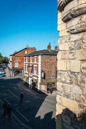 A sunny street scene showing the historic pub and the adjacent modern hotel, viewed from the ancient York city walls.の写真素材