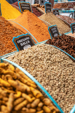 A vibrant, close-up view of a spice stall in Istanbul, with wooden bins filled with various colorful spices and herbs like cloves, curcuma, and salad spice.の写真素材
