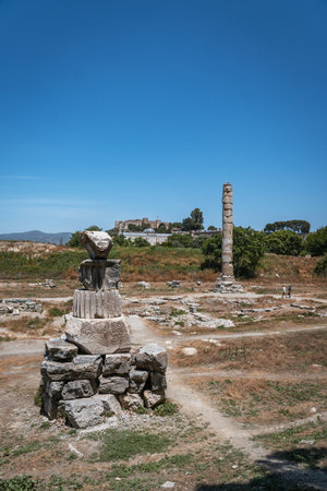 The last remaining column of the Temple of Artemis stands among ancient ruins with Ayasuluk Castle on a hill in the background.の写真素材