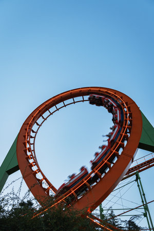 The orange steel track of a roller coaster, known as the American Mountains, stands on its green...