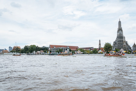 A view of the famous Wat Arun temple complex and its main prang seen from the river.の写真素材