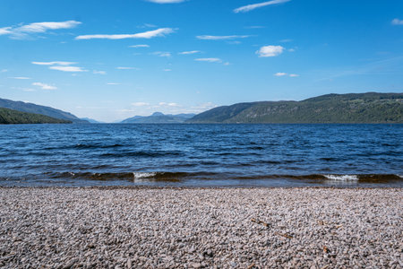 A scenic horizontal view of the vast, deep blue waters of Loch Ness, Scotland, taken from the shingle and pebble beach at Dores.の写真素材