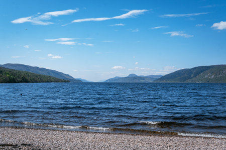 A scenic horizontal view of the vast, deep blue waters of Loch Ness, Scotland, taken from the shingle and pebble beach at Dores.の写真素材