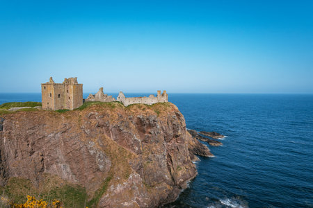 The dramatic ruins of the medieval Dunnottar Castle, an impregnable fortress situated on a rocky headland 160 feet above the North Sea near Stonehaven, Scotland.の写真素材