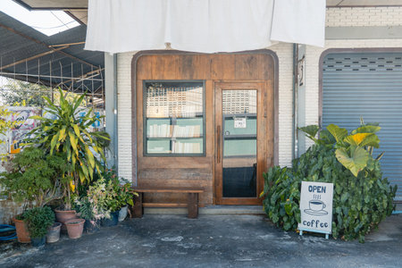 Charming cafe exterior with books in the window and green plants in potsの写真素材