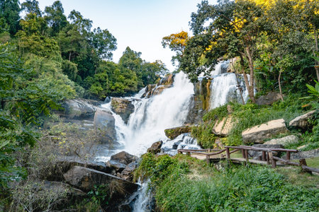 Majestic tropical waterfall flowing over rocks in a lush forestの写真素材