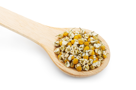 Dried chamomile flowers and wooden spoon isolated on white backgroundの写真素材