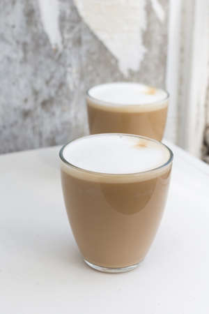 Two Glasses of coffee with cream on white background. High quality photo