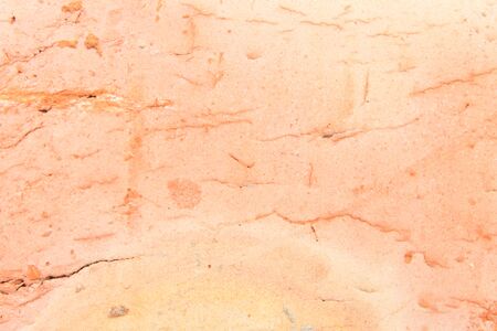 A closeup photo of a brick. Orange background.