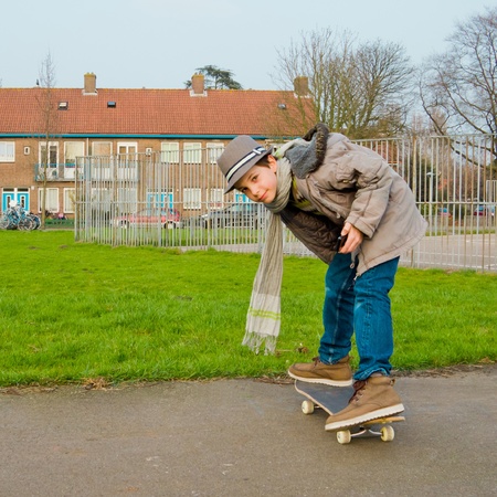Cute teenage boy with mobile phone on the skateboardの写真素材