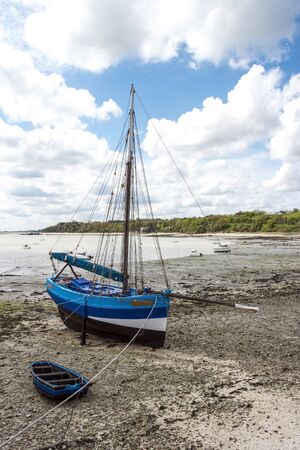 Blue boat at time of low tide, northern coast of Franceの写真素材