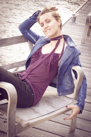 Portrait of beautiful fashionable young woman outdoor sitting near the river. 
の写真素材