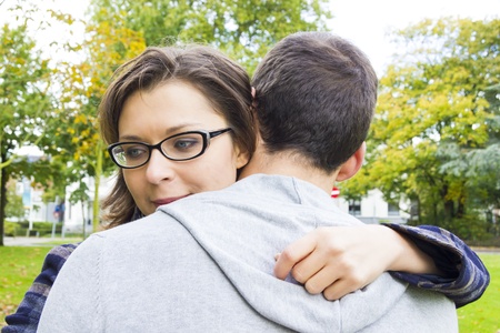 Portrait of love couple embracing outdoor in park looking happyの写真素材