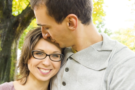 Portrait of love couple embracing outdoor looking happyの写真素材