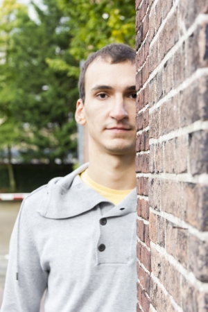 Man peeking from behind a wall cornerの写真素材