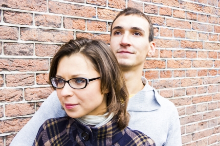 Portrait of love couple embracing looking happy against wall backgroundの写真素材