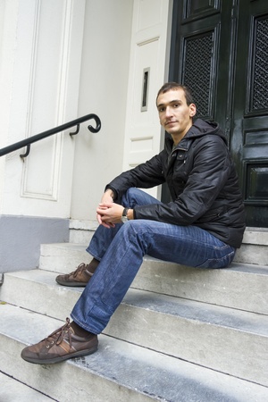 Portrait of young man sitting on traditional Dutch porchの写真素材