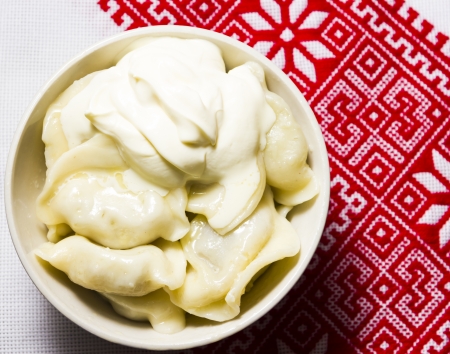 Dumplings with sour cream on the Ukrainian embroidered towelの写真素材