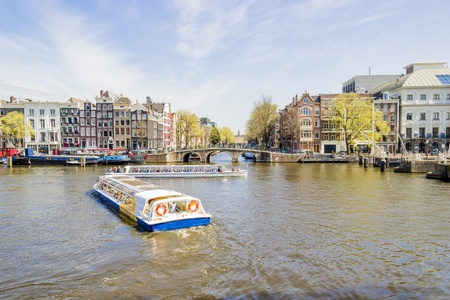 View on the houseboats with cruiseboat in Amsterdam the Netherlandsの写真素材