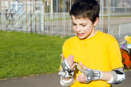 The boy puts on intently roller protection kitの写真素材