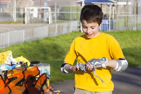 The boy puts on intently roller protection kitの写真素材