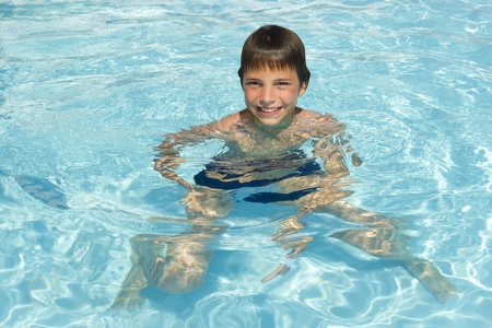 Activities on the pool. Cute boy swimming and playing in water in swimming poolの写真素材