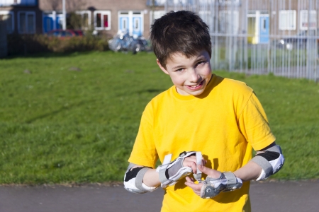 The boy puts on intently roller protection kitの写真素材