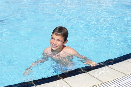 Activities on the pool. Cute boy swimming and playing in water in swimming poolの写真素材