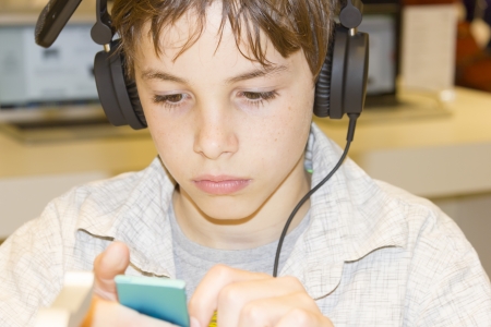 Portrait of a sweet young boy listening to music on headphones