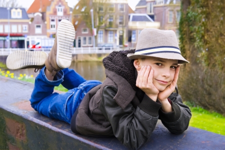 Cute teenage boy lying on the parapet at the parkの写真素材