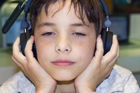 Portrait of a sweet young boy listening to music on headphones