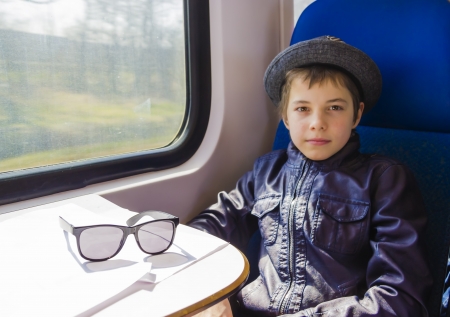 Handsome boy with sunglasses rides on a trainの写真素材