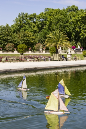 Traditional small wooden sailing boat in the pond of park Jardin du Luxembourg, Paris, Franceの写真素材