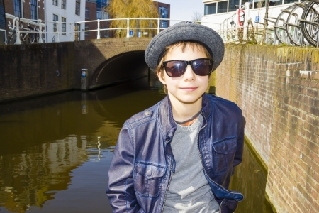 Handsome boy in sunglasses against canal backgroundの写真素材