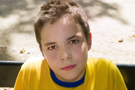 Cute boy smiling at camera in the park on a sunny dayの写真素材