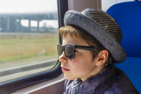 Handsome boy in sunglasses rides on a trainの写真素材