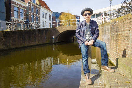 Cute teenage boy against canal backgroundの写真素材