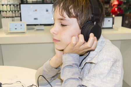 Portrait of a sweet young boy listening to music on headphones