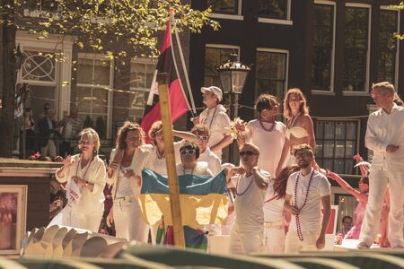 Amsterdam, Netherlands - August 3, 2013: A vintage color tone picture  of Amsterdam gay parade in a canal on a sunny day with people having fun dancing on a boatのeditorial素材