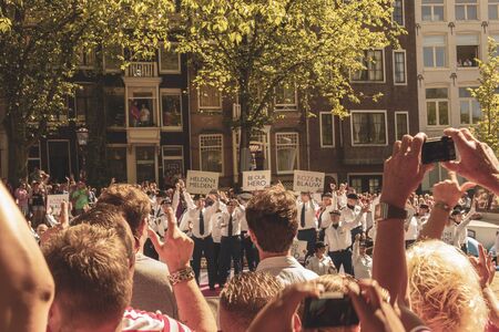 Amsterdam, Netherlands - August 3, 2013: A vintage color tone picture  of Amsterdam gay parade in a canal on a sunny day with people greeting prideのeditorial素材