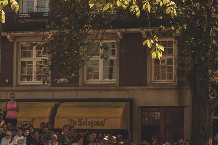 Amsterdam, Netherlands - August 3, 2013: A vintage color tone picture  of Amsterdam gay parade in a canal on a sunny day with people greeting prideのeditorial素材