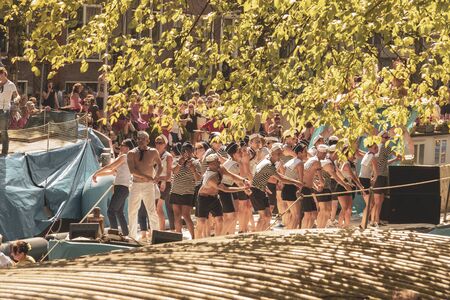Amsterdam, Netherlands - August 3, 2013: A vintage color tone picture  of Amsterdam gay parade in a canal on a sunny day with people having fun dancing on a boatのeditorial素材