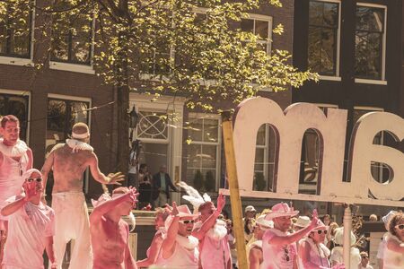 Amsterdam, Netherlands - August 3, 2013: A vintage color tone picture  of Amsterdam gay parade in a canal on a sunny day with people having fun dancing on a boatのeditorial素材