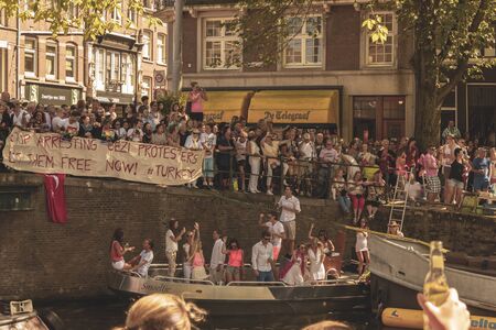 Amsterdam, Netherlands - August 3, 2013: A vintage color tone picture  of Amsterdam gay parade in a canal on a sunny day with people greeting prideのeditorial素材