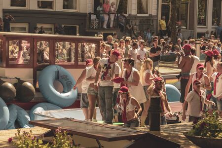 Amsterdam, Netherlands - August 3, 2013: A vintage color tone picture  of Amsterdam gay parade in a canal on a sunny day with people having fun dancing on a boatのeditorial素材