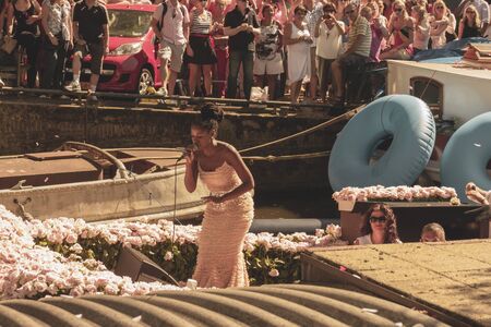 Amsterdam, Netherlands - August 3, 2013: A vintage color tone picture  of Amsterdam gay parade in a canal on a sunny day with people having fun dancing on a boatのeditorial素材
