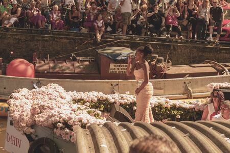Amsterdam, Netherlands - August 3, 2013: A vintage color tone picture  of Amsterdam gay parade in a canal on a sunny day with people having fun dancing on a boatのeditorial素材